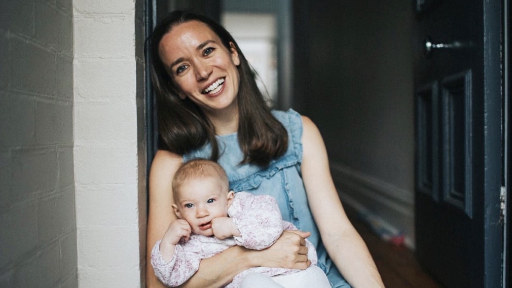 SWS, Stella Women Series, Etta Watts-Russell, Lactamo. Woman smiling holding a baby.